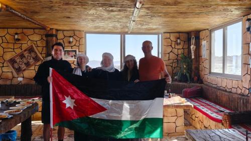 a group of people holding a flag in a room at Dana bedouin Sky in Dana