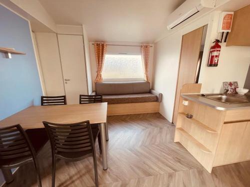 Cette petite chambre comprend une table, des chaises et un lit. dans l'établissement Mobil Home Jasmins 1, à Valras-Plage