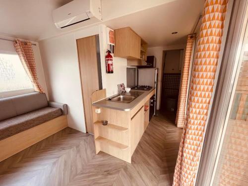 - une petite cuisine avec évier dans une petite pièce dans l'établissement Mobil Home Jasmins 1, à Valras-Plage