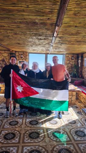 a group of people holding a flag in a room at Dana bedouin Sky in Dana