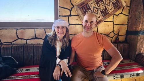 a man and a woman sitting on a bed at Dana bedouin Sky in Dana