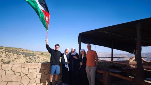 a group of people holding up a flag at Dana bedouin Sky in Dana