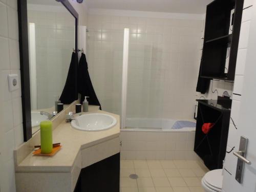 een badkamer met een wastafel, een toilet en een bad bij Apartamento Raio de Sol in Caniço