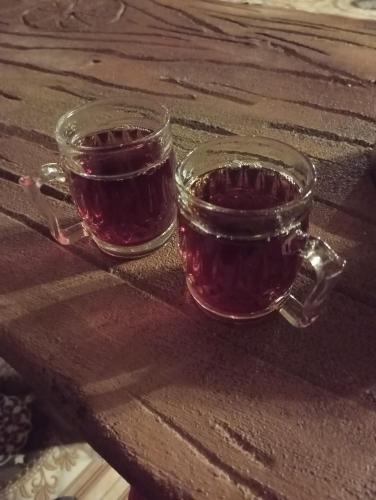 two glasses of red wine sitting on a wooden table at Dana bedouin Sky in Dana