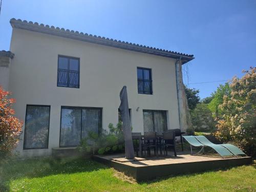 a white house with a table and chairs in front of it at Domaine Ecoline in Sadirac