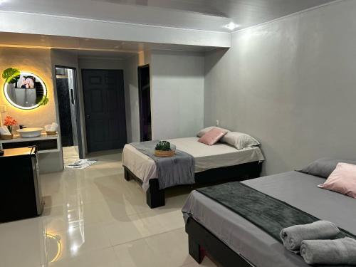 a hotel room with two beds and a mirror at Residencia Esmeralda in Agua Buena