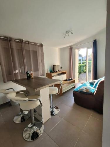 un salon avec une table, des chaises et un canapé dans l'établissement Maison charmante avec vue sur la montagne à Prunelli di Fiumorbo, à Prunelli-di-Fiumorbo