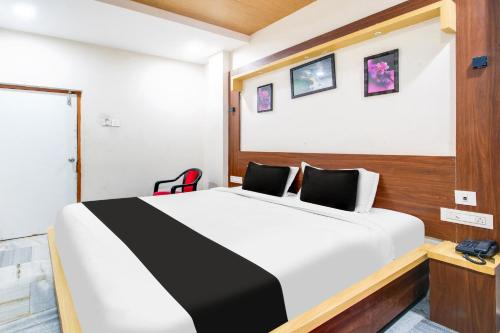 a bedroom with a black and white bed in a room at Super Hotel O Gurudwara Near RTC Complex in Visakhapatnam