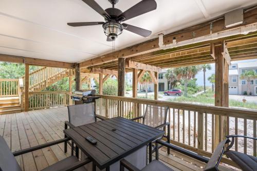 a porch with a table and a ceiling fan at The Surf Shack by Gulf Coast Getaways in Pensacola Beach