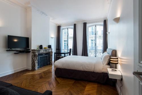 une chambre d'hôtel avec un lit et une cheminée dans l'établissement Paris Square, à Paris