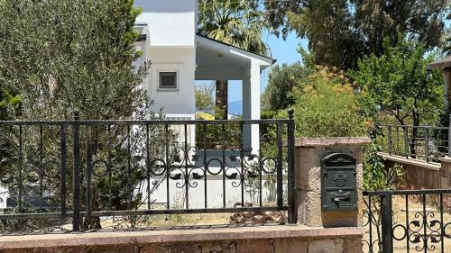 a gate in front of a white house at Relaxing Stay by the Beach in Ayvalık