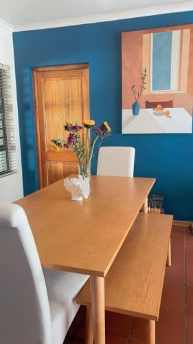 a wooden table with flowers in a dining room at Serene Seven in Clarens