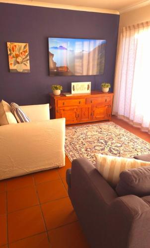 a living room with a couch and a flat screen tv at Serene Seven in Clarens