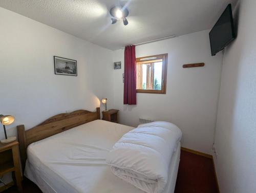une petite chambre avec un lit et une télévision dans l'établissement Le balcon des Ecrins, à Orcières