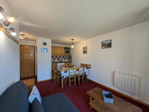 un salon avec un canapé et une table dans l'établissement Le balcon des Ecrins, à Orcières