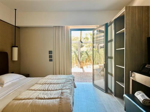 a bedroom with a large bed and a sliding glass door at Vallegrande Nature Resort by Geocharme in Cefalù