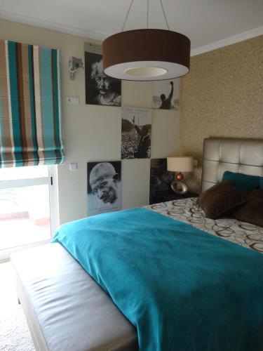 a bedroom with a bed with a blue blanket on it at Apartamento Raio de Sol in Caniço