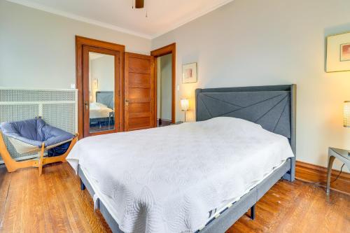 a bedroom with a large white bed and a chair at Walkable Apt 4 Mi to Downtown Toledo! in Toledo