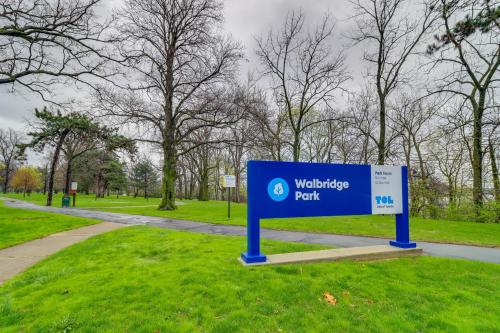 a blue sign in the grass next to a path at Walkable Apt 4 Mi to Downtown Toledo! in Toledo