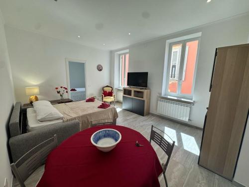 a living room with a bed and a red table at Splendida Casa vista mare per 4 persone di fronte alle spiagge di Bussana in Bussana Nuova
