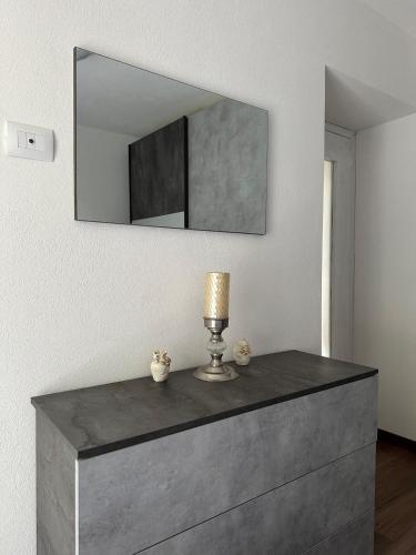 a dresser with a lamp and a mirror on the wall at Casa Verde Valsassina 2 in Primaluna