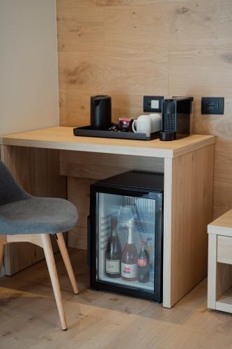 a room with a desk with a fireplace and a chair at Mostesi Dolomites Spa Hotel in Auronzo di Cadore