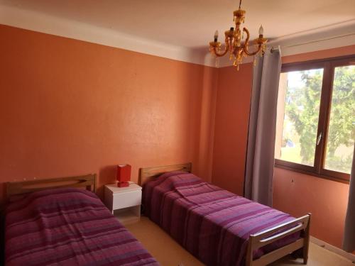 une chambre avec deux lits et une fenêtre dans l'établissement les campanules, à Saint-Aygulf
