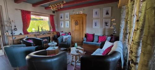 a living room with couches and chairs at Les 4 Saisons in Kruth