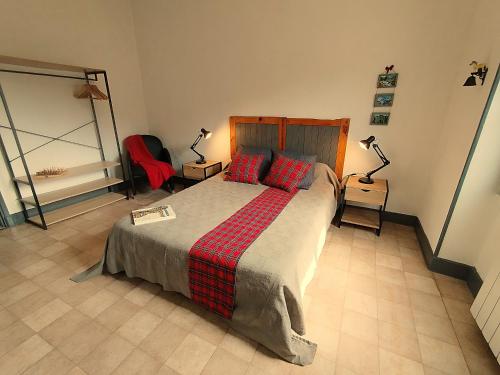 - une chambre avec un lit doté d'oreillers rouges et de 2 lampes dans l'établissement Le Sancy gîte Murol, à Murol