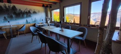 a restaurant with tables and chairs and windows at Les 4 Saisons in Kruth