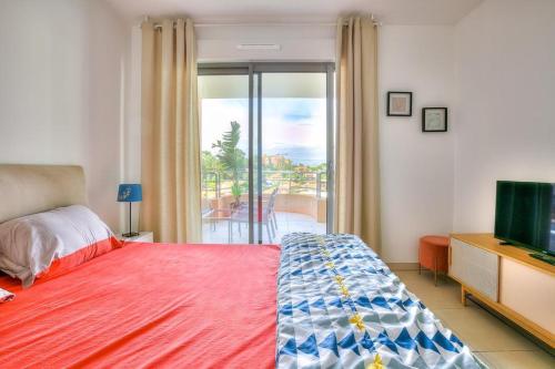 a bedroom with a bed and a television and a balcony at 2Bedrooms, Thèoule-sur-mer in Théoule-sur-Mer