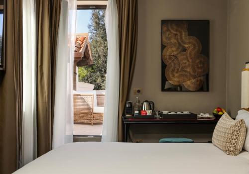 a bedroom with a bed and a desk and a window at U-Visionary Venezia Hotel in Venice