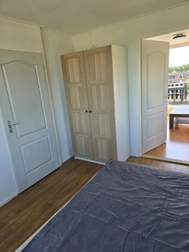 an empty room with a bed and two doors at Cozy stay with beautiful balcony in Utrecht in IJsselstein