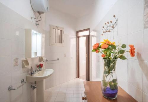 a bathroom with a vase of flowers on a table at Chill e Relax Sul Mare in Sant'Isidoro