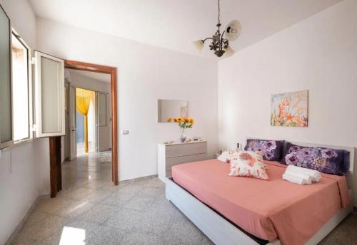 a bedroom with a bed with pink sheets and pillows at Chill e Relax Sul Mare in Sant'Isidoro