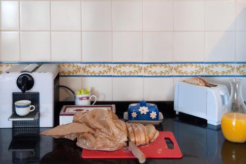 エリセイラにあるEriceira T2 Navegantes Apartmentのキッチン(テーブル、カッティングボード、ペストリー付)