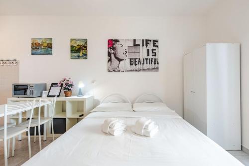 a white bedroom with two beds and a desk at Beachfront Studio Free Parking-Pool 50m from Sea in Chioggia