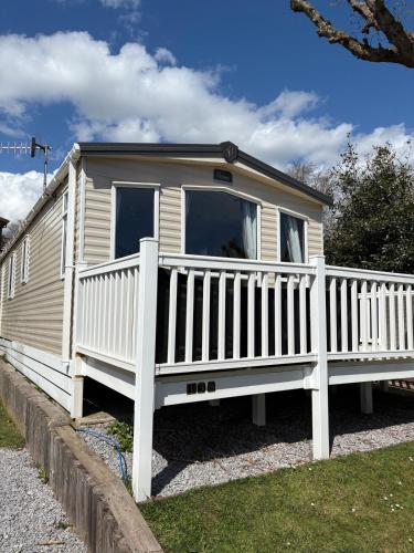 a mobile home with a white fence at Ladram Bay, 2 Bedroom, Pet Friendly, Wi-Fi, Sleeps 6 in Otterton