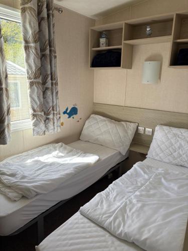 a room with two beds and a window at Ladram Bay, 2 Bedroom, Pet Friendly, Wi-Fi, Sleeps 6 in Otterton
