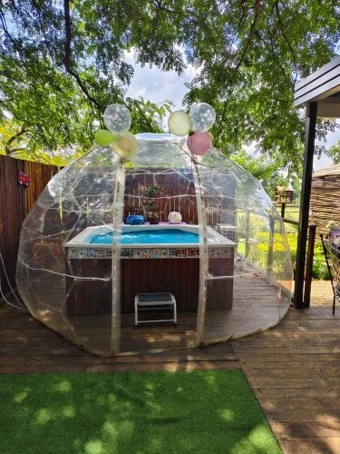 a bubble tent with a hot tub in a yard at Windsong Living The Nest in Krugersdorp