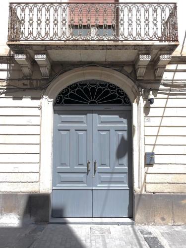 a blue door on a building with a balcony at Casa Ma Pì - relax e comfort nel centro di Augusta in Augusta