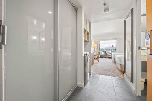 a hallway with a glass door leading to a bedroom at Studio with Partial Ocean View & Balcony Unit 1901 in Honolulu
