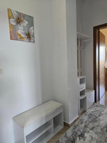 a white bench in a room with a wall at Prima Apartments in Pogradec