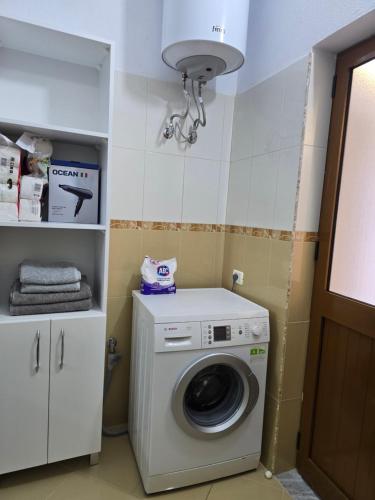 a washer and dryer in a bathroom with a light at Prima Apartments in Pogradec