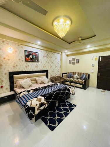 a bedroom with a bed and a chandelier at NAMAH RESORT HOMESTAY with KITCHEN Near PREM MANDIR in Vrindāvan