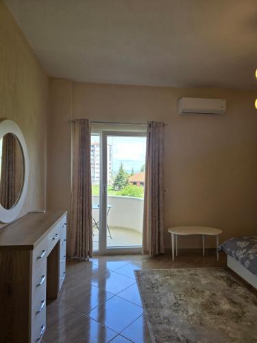 a bedroom with a bed and a sliding glass door at Prima Apartments in Pogradec