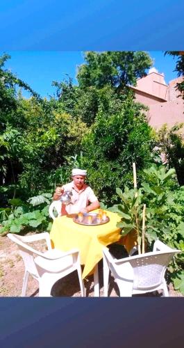a man sitting at a table with a yellow table cloth at DAR Moha dades in Aït Ougliff