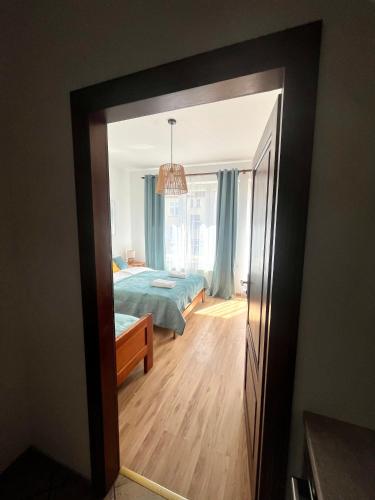 a view of a bedroom through a doorway at Agapella Apartamemty- Villa Agapella 250m from the beach in Sopot
