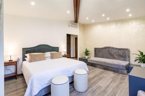 a bedroom with a large bed and a couch at Agriturismo Villa Godenano - Pool&Restaurant in Castellina in Chianti