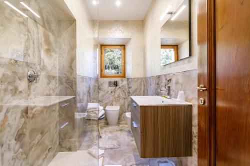a bathroom with a sink and a shower and a toilet at Agriturismo Villa Godenano - Pool&Restaurant in Castellina in Chianti